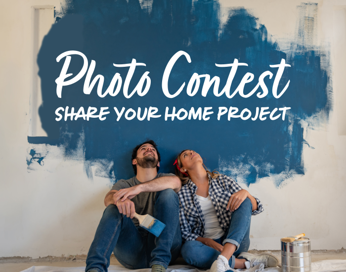 Man and woman sitting amongst painting supplies, leaning up against a partially painted blue wall looking up at text that reads Photo Contest. Share your home project.
