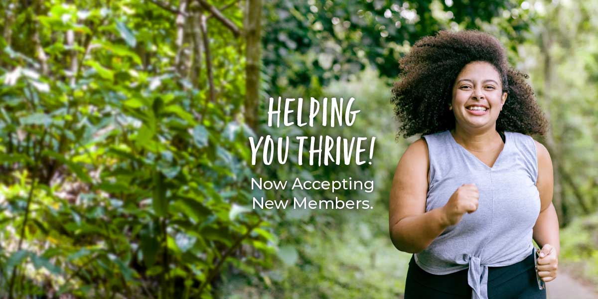 Woman jogging in the woods. Text reads helping you thrive. Now accepting new members.