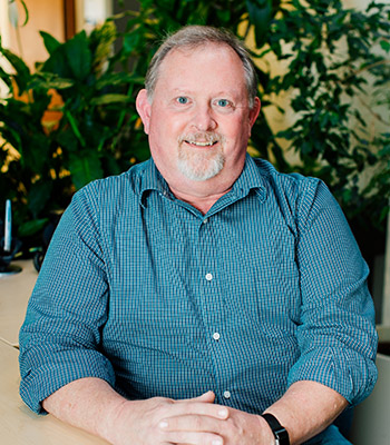 Photo of Supervisory Committee Member David Rudy sitting at a desk.