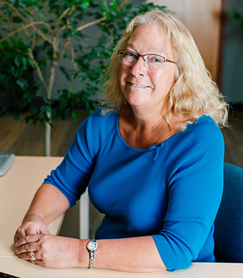 Photo of Supervisory Committee Member Sheryl Cartwright sitting at a desk.