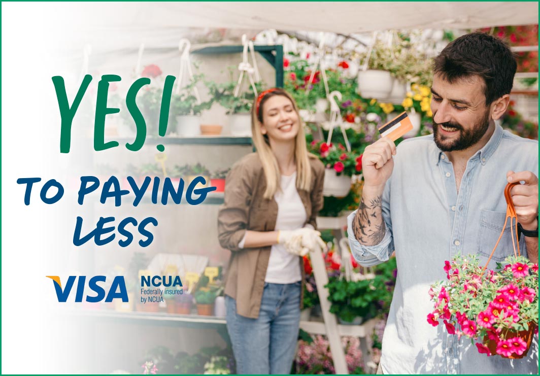 Man excitedly holds a hanging plant and his credit card. Nursery worker is behind him smiling. Text reads Yes! To paying less. Vis and NCUA logos.